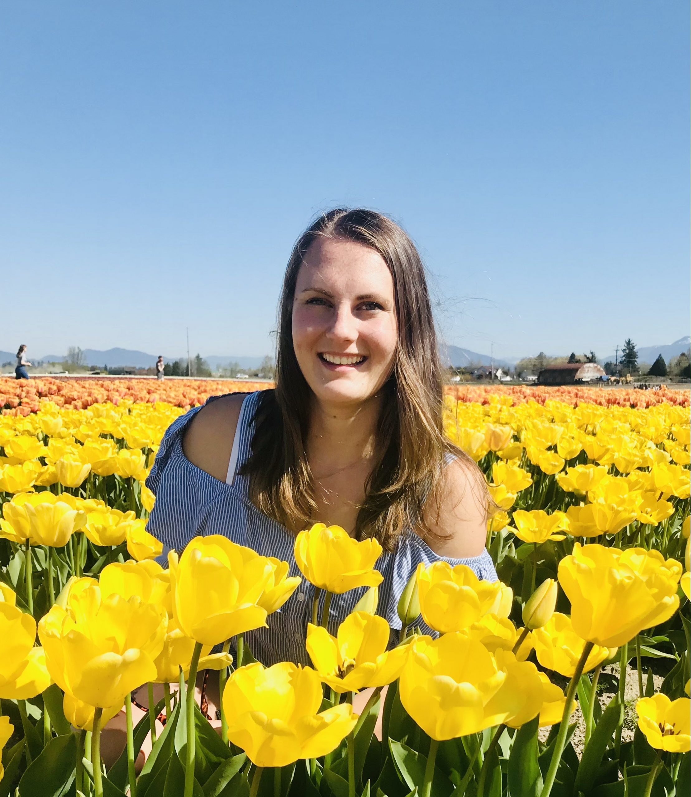 Gabriella Labazzo headshot in field of yellow tulips.