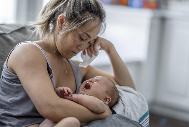 Woman holding a crying child.