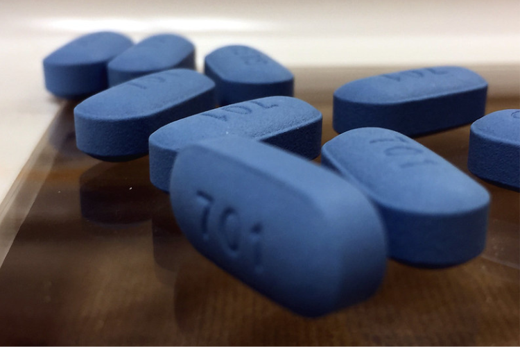 Several blue pills on wooden table